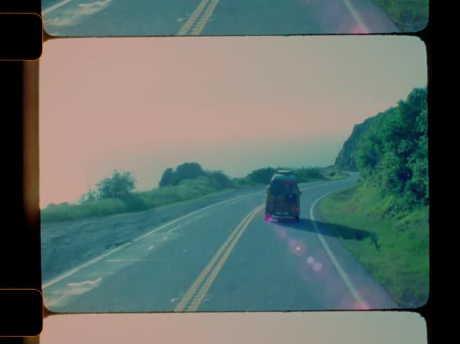 A van turns on the long cliff side highway