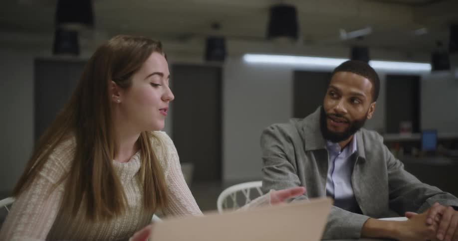 A man is talking with a woman in the office