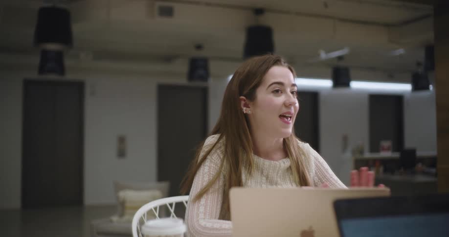 Coworkers with laptop computers in front of them having a discussion at a table