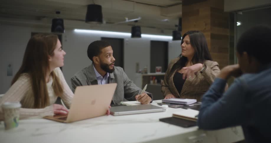 Workers are listening to a woman at a meeting