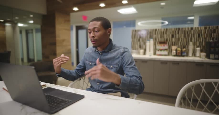 Man talking in an office with a pc