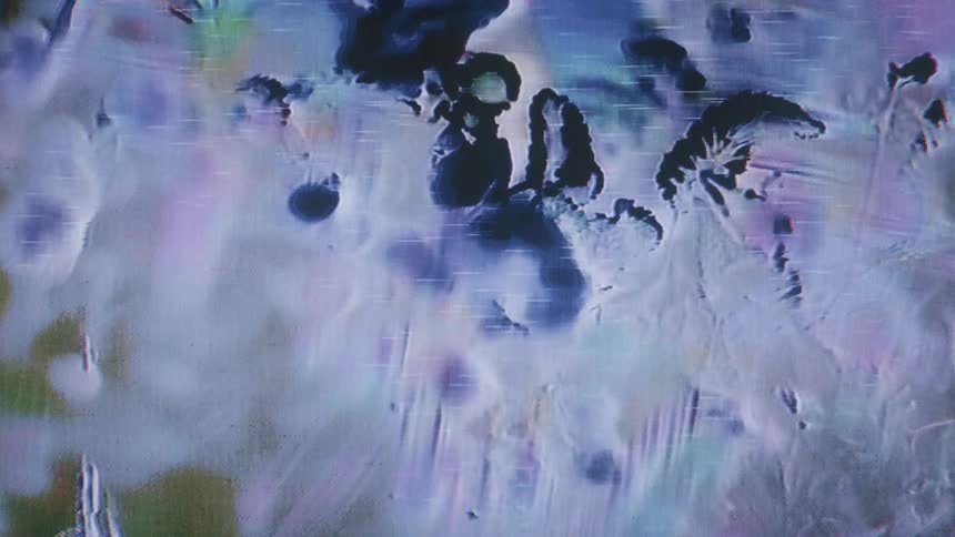 A closeup of a screen reveals pixelated abstract shapes and patterns in blue and purple tones