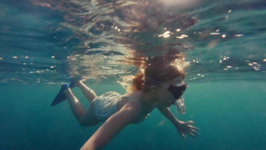 Little girl swimming in the sea with a mask