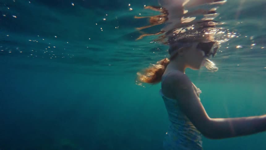 Girl swimming underwater with a snorkel