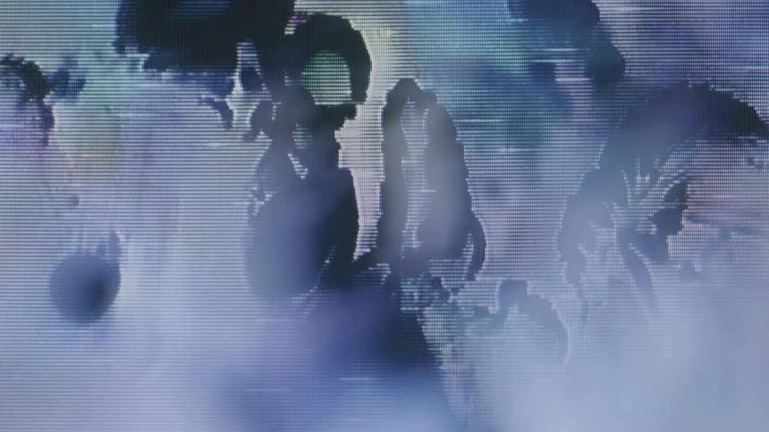 A closeup of a screen reveals pixelated abstract shapes and patterns in blue and purple tones