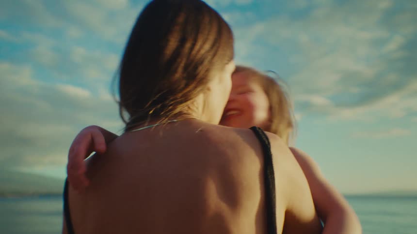 A mother hugs and kisses her daughter