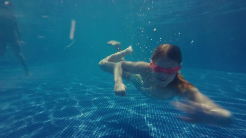 Girl swimming happily under the water