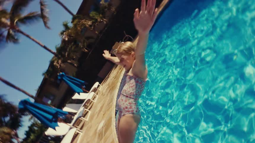 A girl falls backwards into the pool