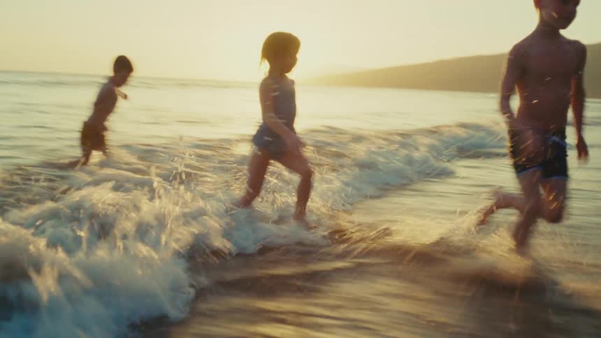 Family runs from the shallow water to the beach