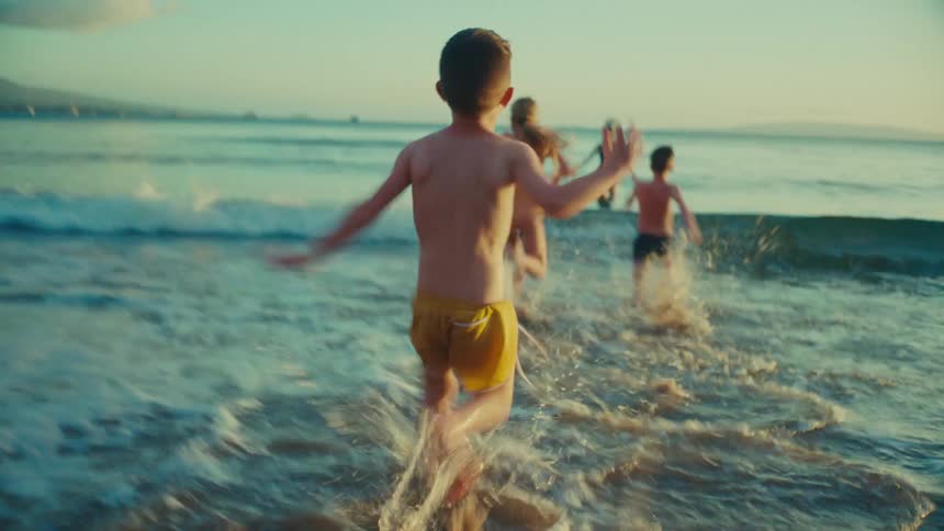 Children run into the water at a beach