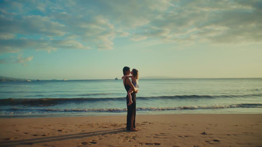 Mom holding her daughter on a beach
