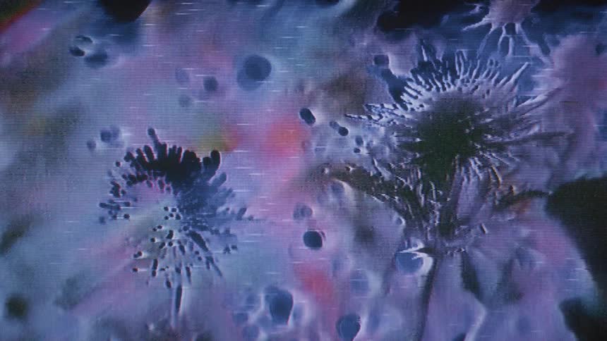 A distorted screen like image displays abstract spiky formations on a multicolored grainy background with scan lines
