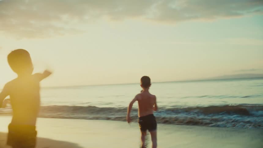 Children run to a woman on the beach