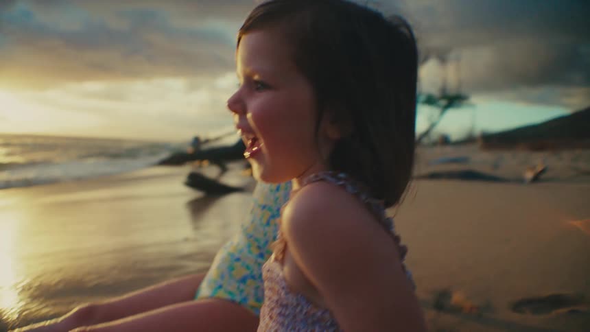 Little girls in costume sitting on the beach talking