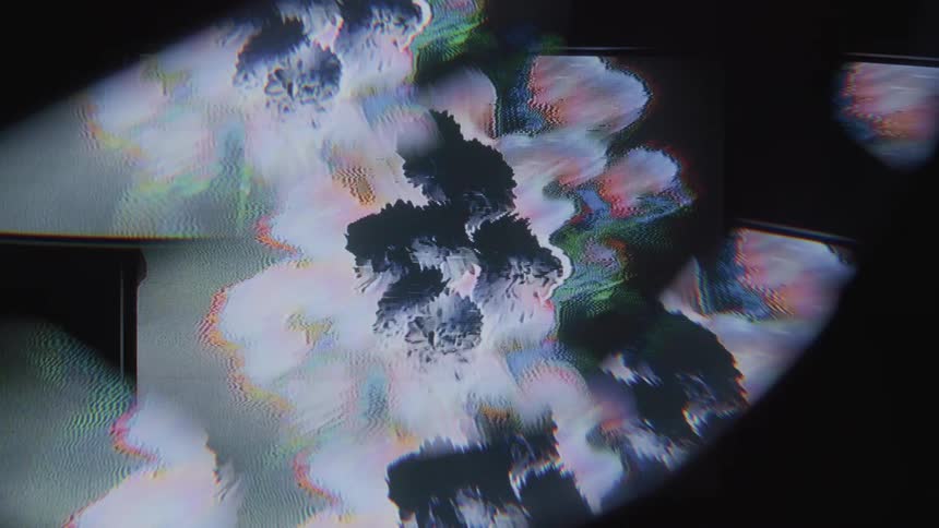 An abstract visual displays rippling filmlike static and distortion effects moving across the frame