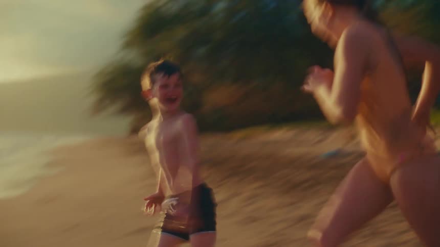 A family have fun splashing in the water of the beach