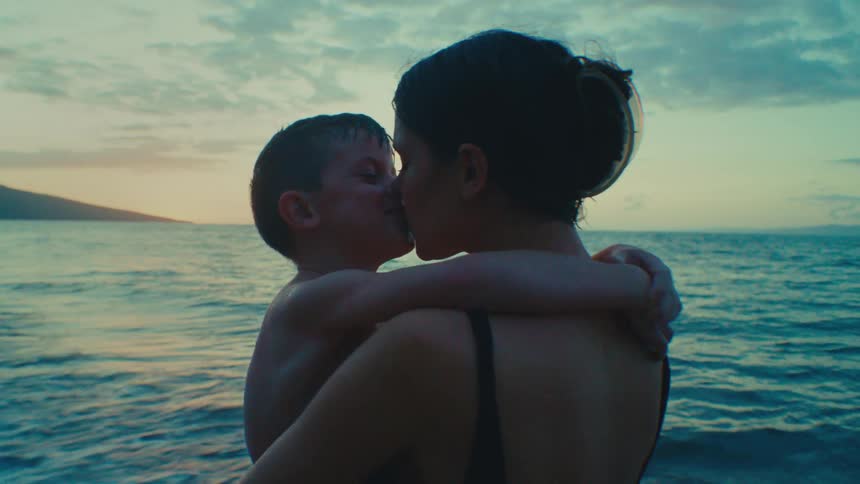 A Playful Kiss Between Mother and Son by the Sea