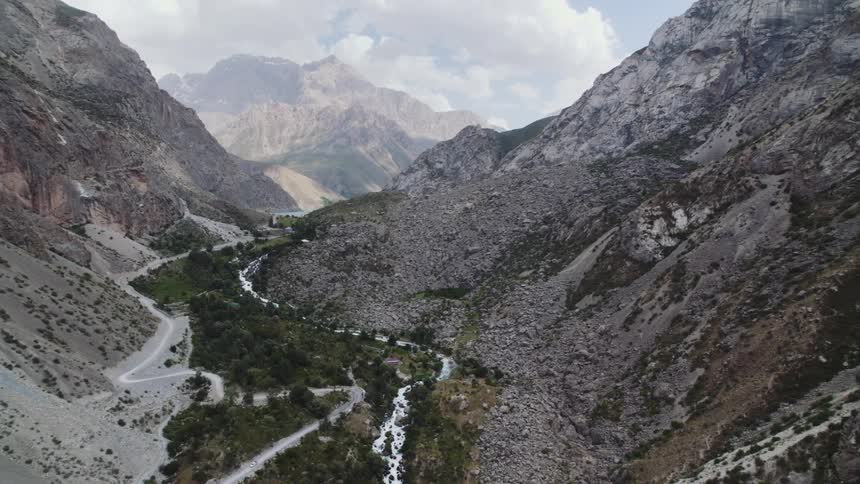 A winding river flowing through a deep valley surrounded by rocky mountains