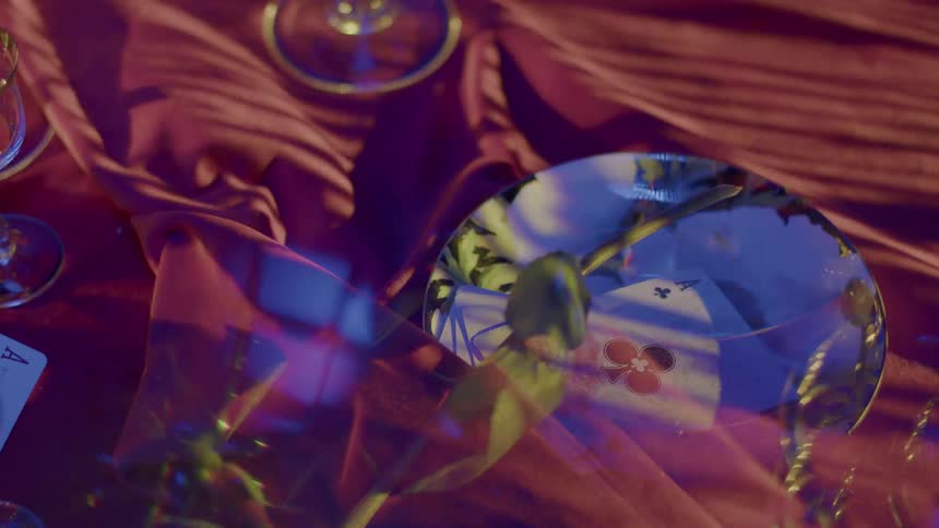 The moving sun casts moving shadows over dishes containing cards on a tablecloth