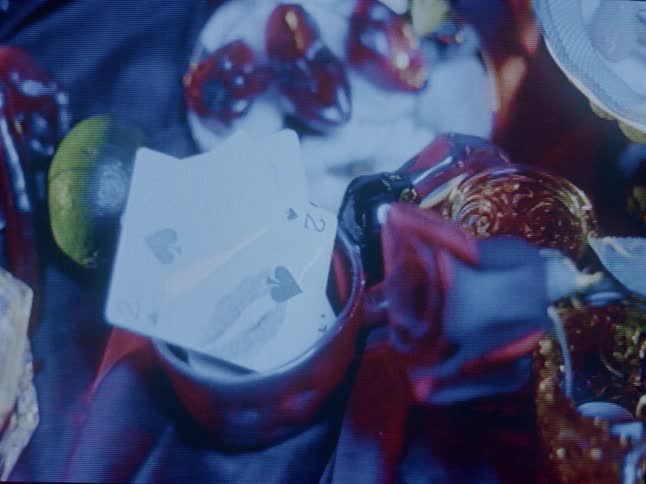Light flickers over pottery containing cards and trinkets