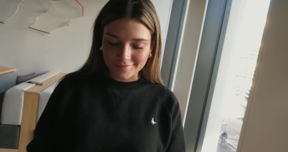 A footage of a lady operating a smartphone in the room