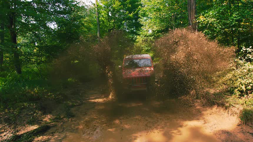 The vehicle splashes mud all over in the forest