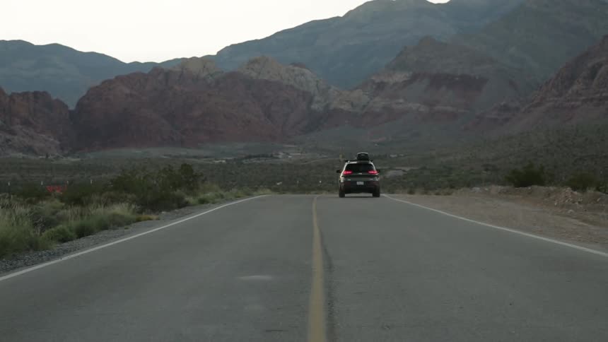 A person waving out of their car window