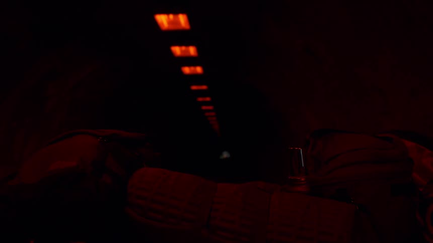 A motorcyclist enters and rides through a dim tunnel