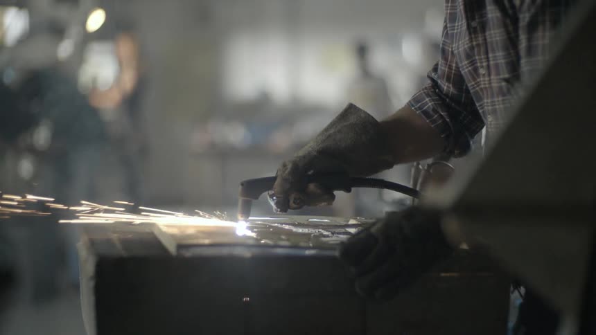 Man wearing work gloves uses a hot tool