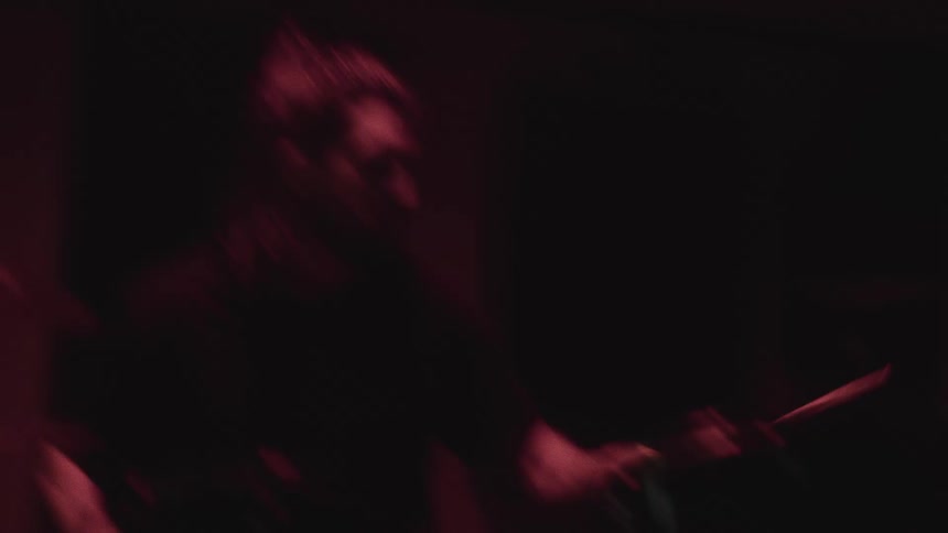 Male drummer plays the drums indoors at night