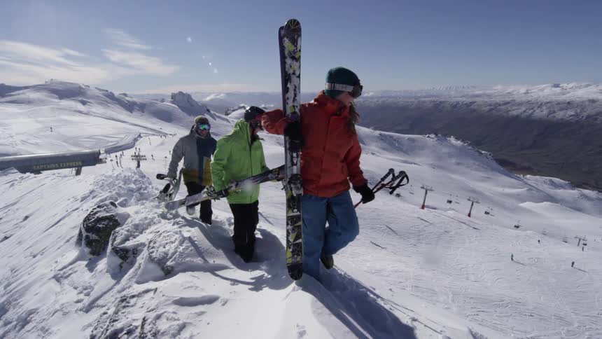 People walking up a mountain with ski equipment