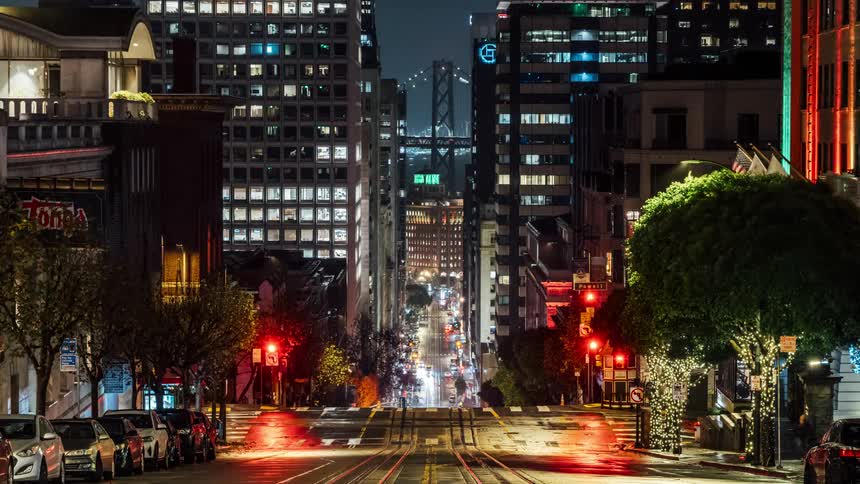 Cars drive through the bright city at night