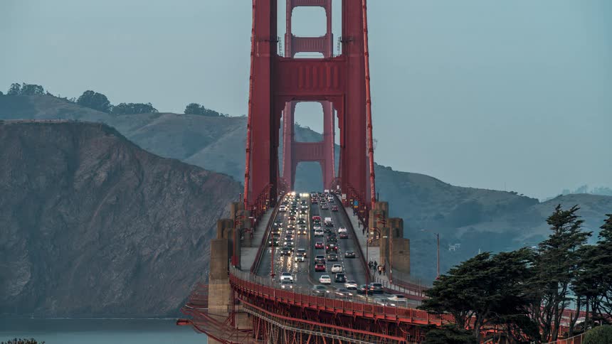 Vehicles and pedestrians cross the golden gate bridge during sunrise afternoon and at night