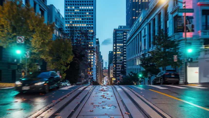 Timelapse of night transitioning to day on a city street with streetcar tracks running down the center bustling with traffic and lively activity