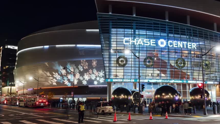 Crowds of people enter and leave the stadium at night