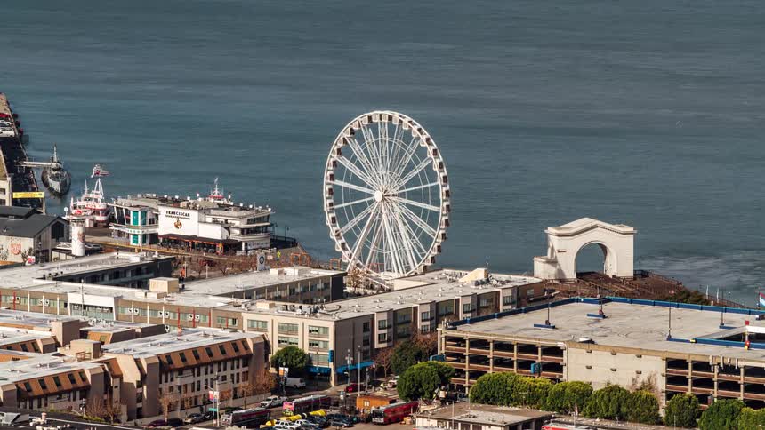 A ferris wheel is spinning on the shore