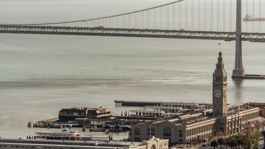 Traffic travels in the water and the bridge by the city