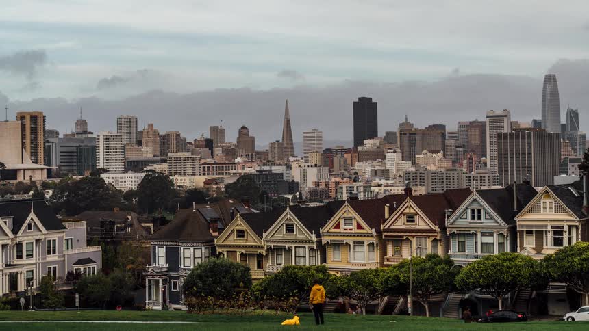 Big city with a nice lawn and people walking by