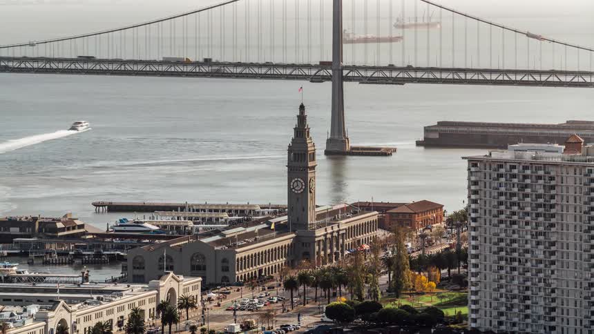 View of a busy city with a bridge and a tower with a clock