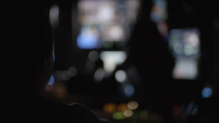 A person sitting in a room watching something on a television