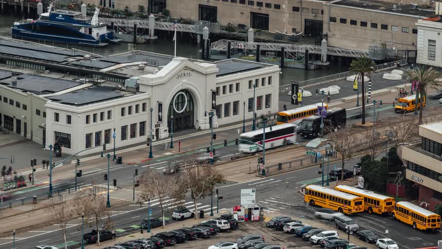 Time lapse of a busy city intersection near a river harbor