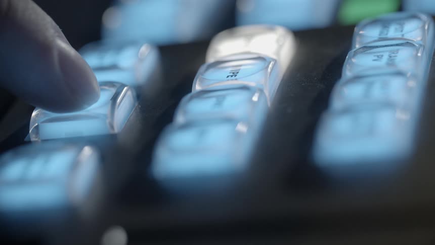 A finger pushes illuminated buttons on TV switcher