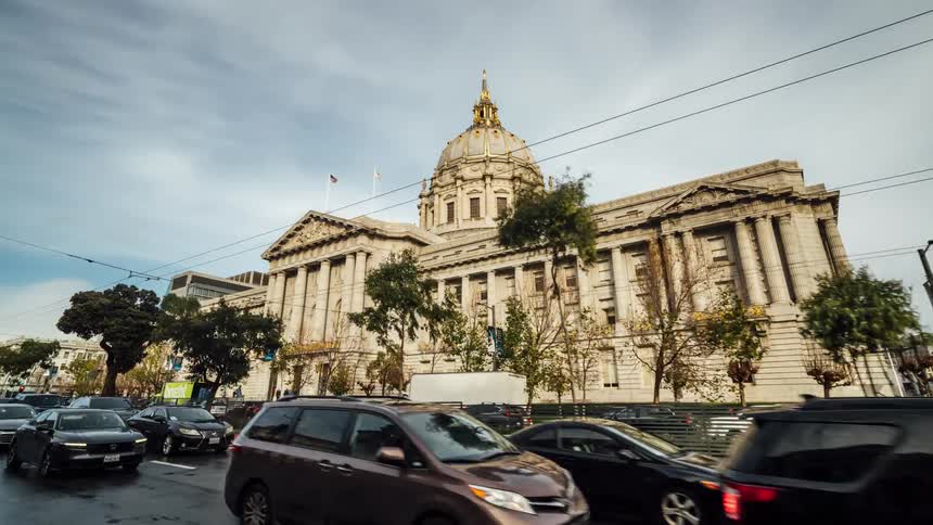 Heavy traffic on a treelined street outside the capitol building