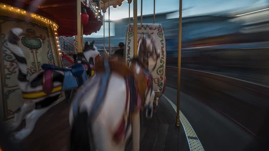 People walk by the spinning carousel