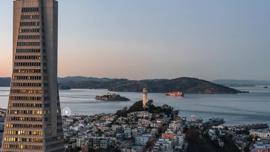 Top view of a city with many buildings and a tower also the sea in the background