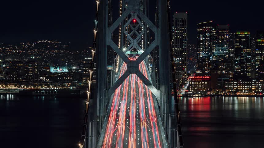 Lights from the traffic fill the bridge by the city