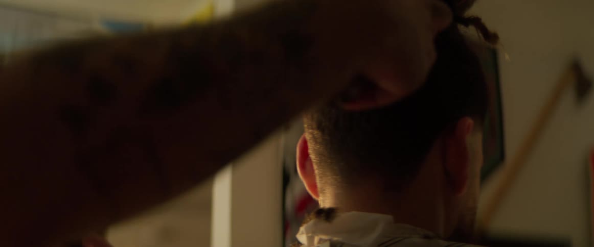 Customer getting his hair buzzed with electric razor at barbershop