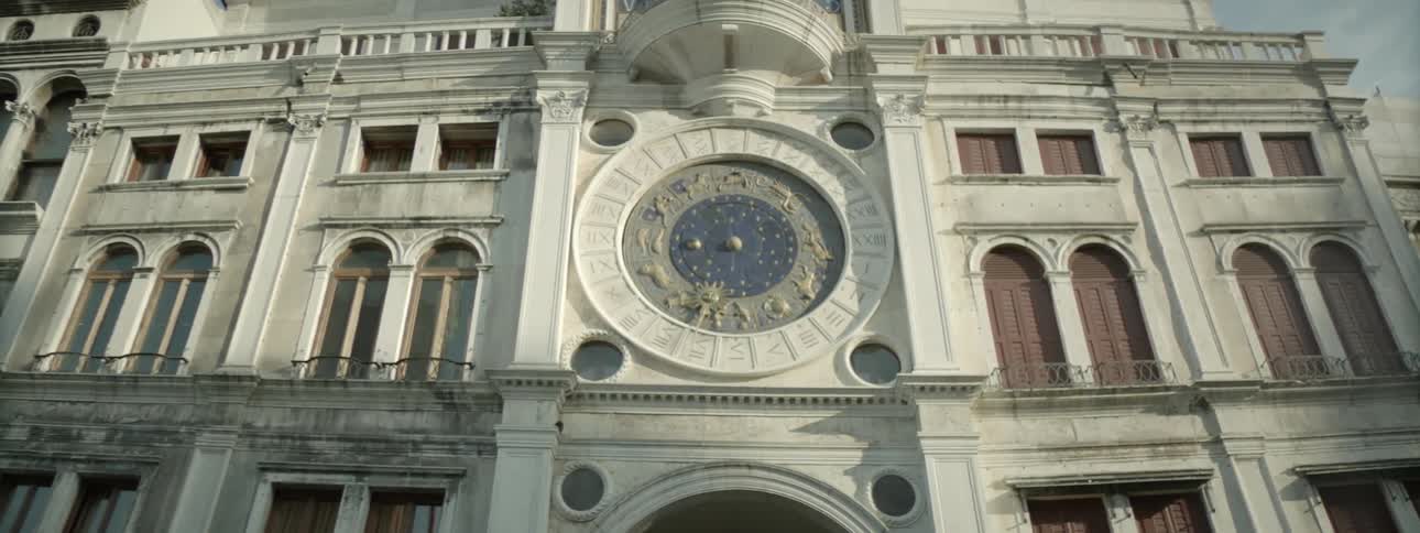A large building has a clock in the middle of the it