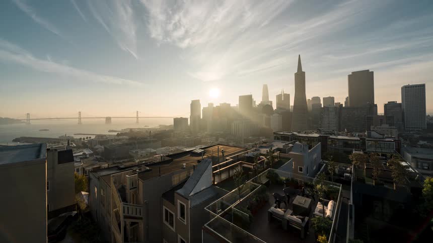Aerial time lapse of a sunrise over a harbor and metropolitan area