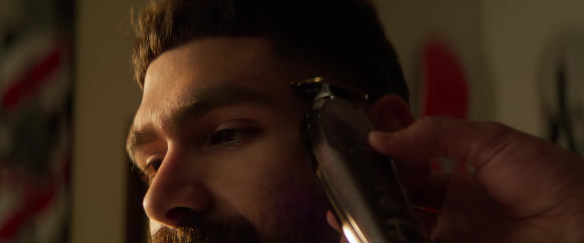 Customer having his hairline shaved with electric razor at barbershop